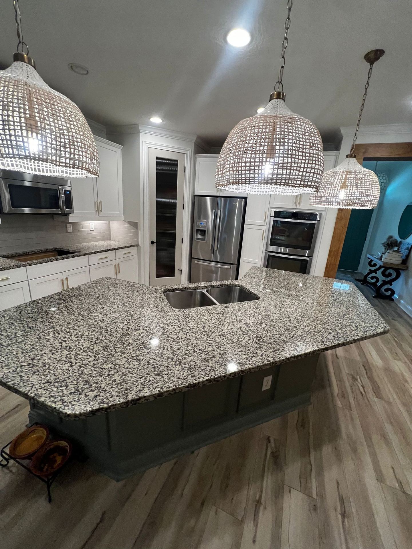 Completed kitchen renovation with premium granite and rattan pendants
